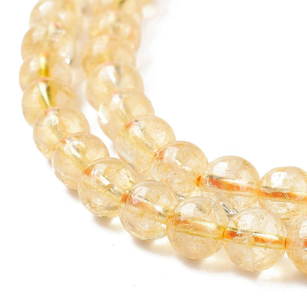 A strand of 62+ citrine beads, golden coloured, 6mm in size, round shaped