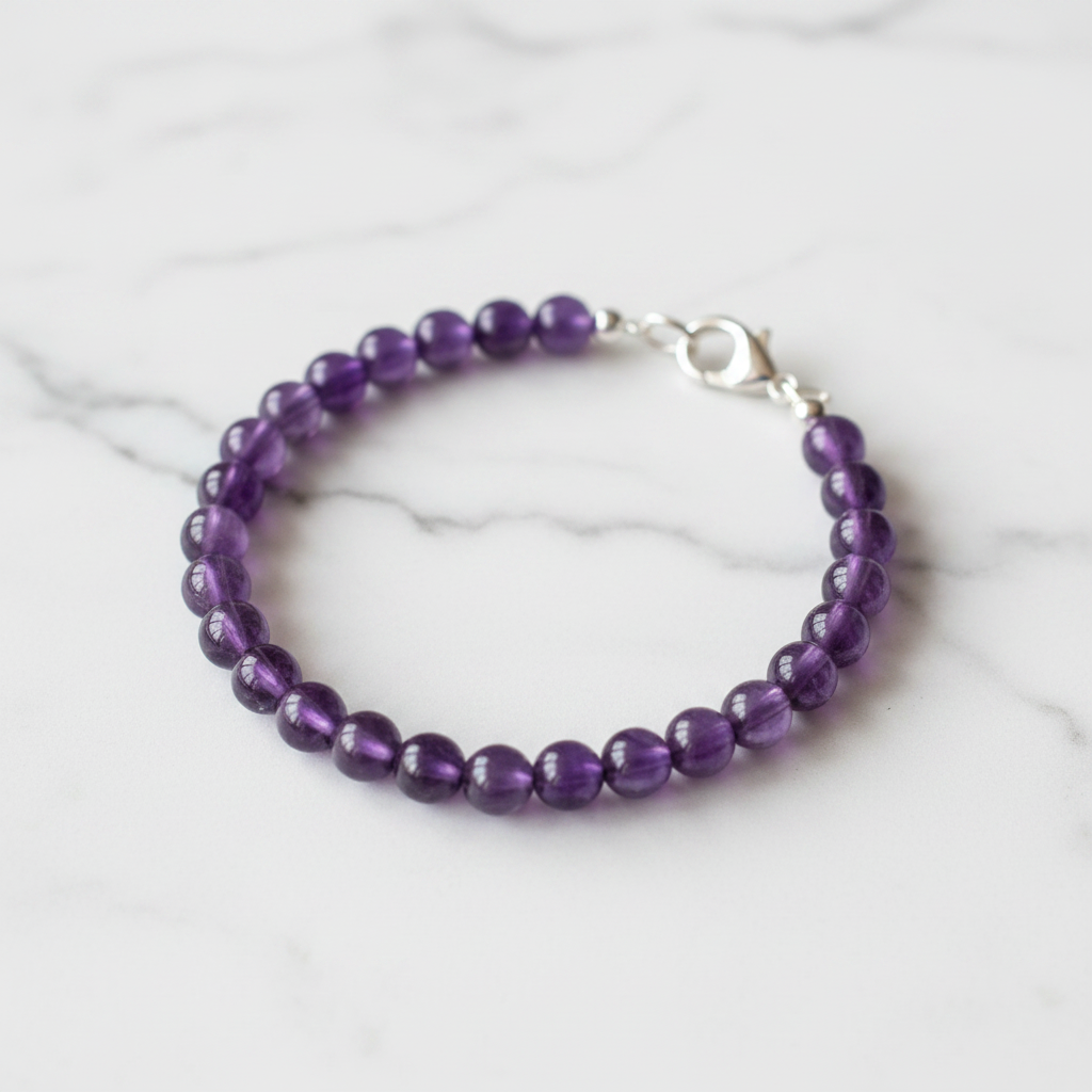 Finished bracelet made from purple amethyst 6mm beads with silver lobster clasp on white marble