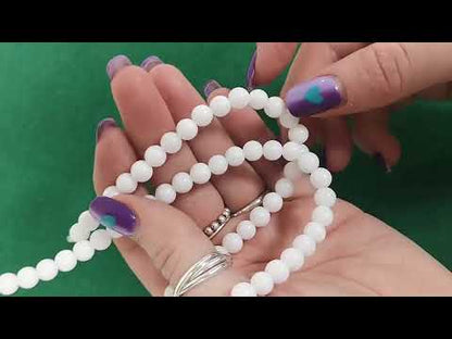 A strand of 60+ malaysian beads, white in colour, 6mm in size, round shaped
